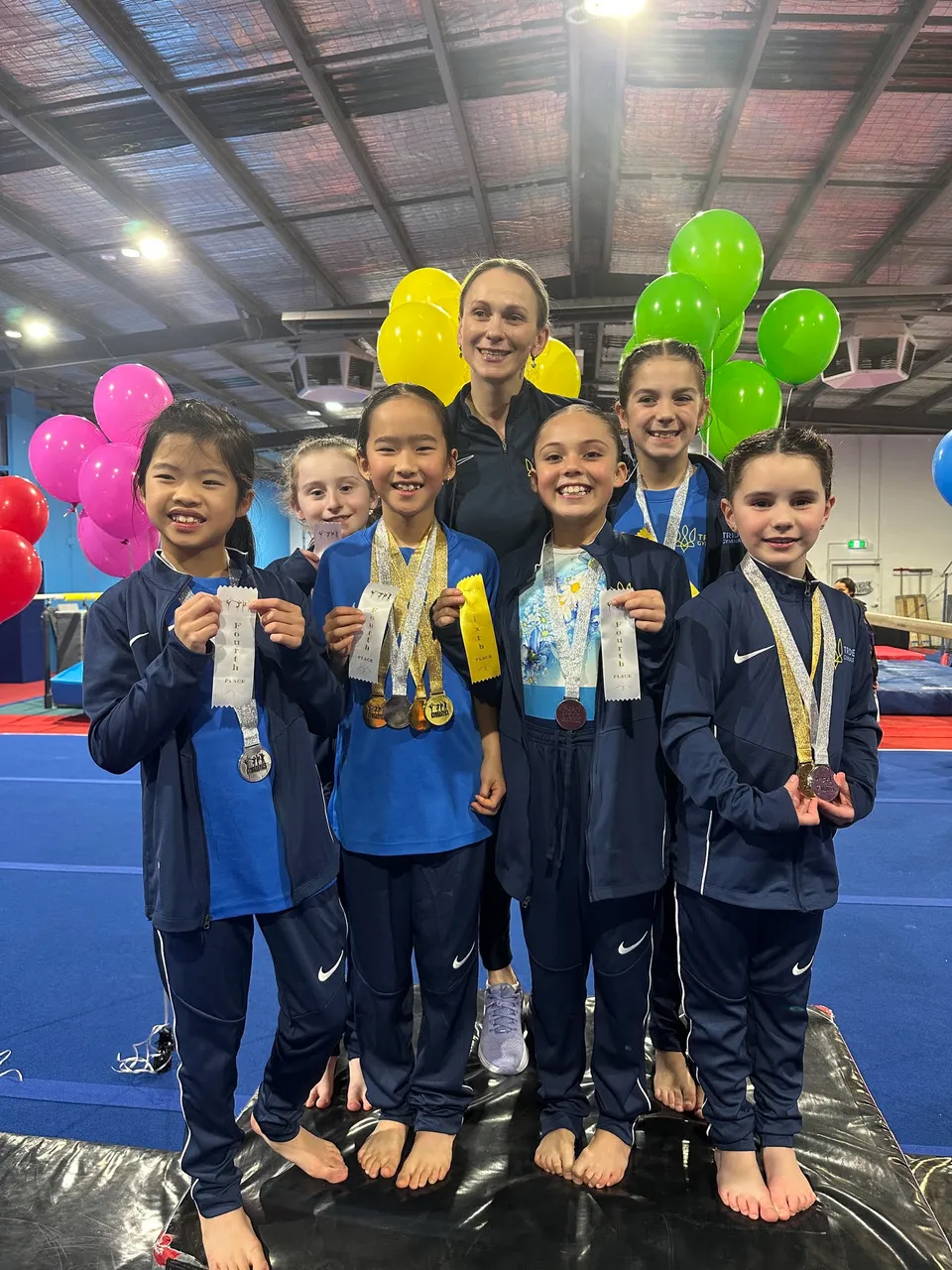 Trident squad gymnasts with their coach after the AGC competition